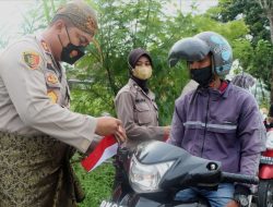 Kenakan Pakaian Adat, Kapolres Sergai Bagikan Bendera Merah Putih Kepada Warga